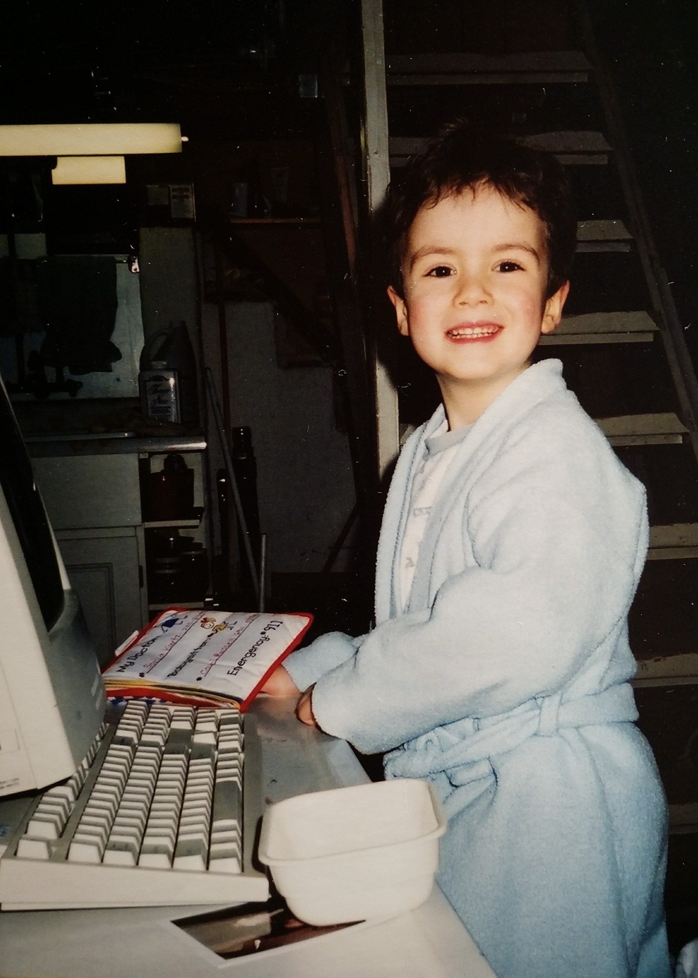 Sam as a child infront of a computer.